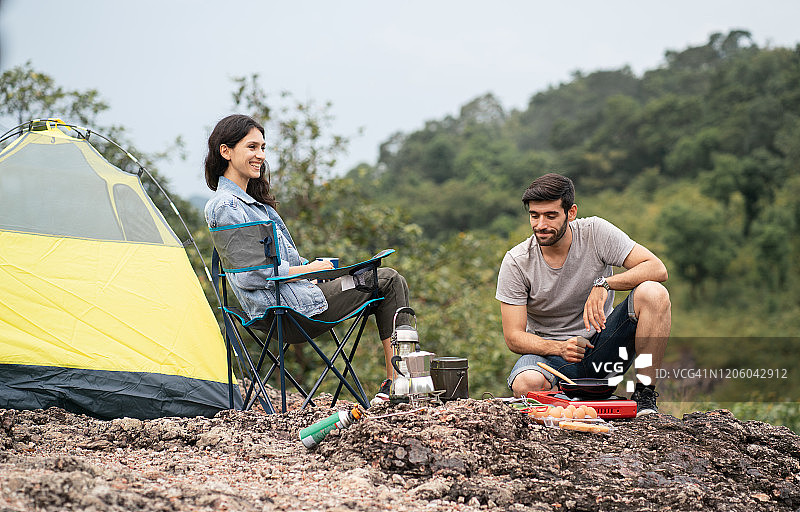 假期里，年轻甜蜜的情侣们在山营里准备做饭的材料。图片素材