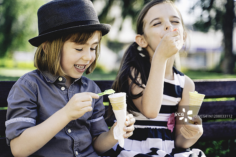 孩子们在吃冰淇淋。公园里的朋友。图片素材
