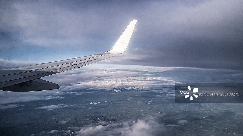 鸟瞰图从飞机窗口，飞机机翼和云图片素材