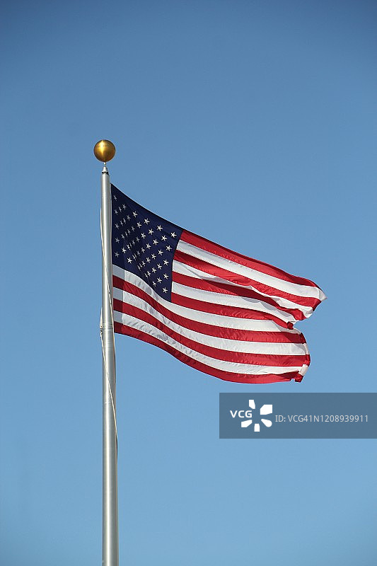 一面美国国旗在风中飘扬，天空湛蓝图片素材