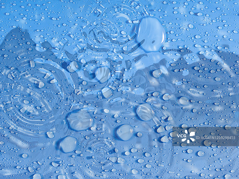 雨水滴在蓝色的背景上。图片素材