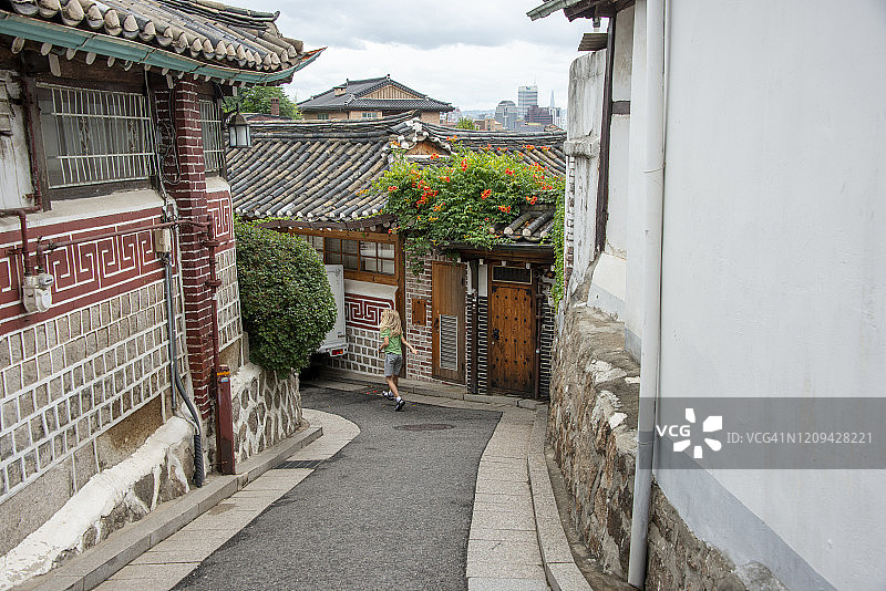 小男孩走在北川韩屋村，韩国首尔历史街区图片素材