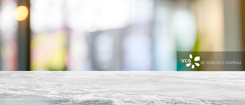 空的白色大理石石材桌面和模糊玻璃窗内部餐厅横幅模拟抽象背景-可以用来展示或蒙太奇您的产品。图片素材