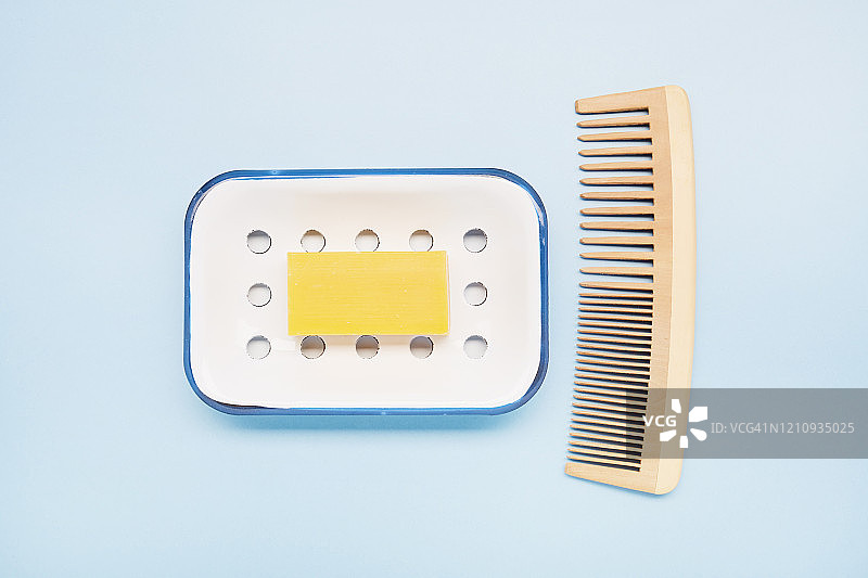 高角度的头发肥皂，肥皂盘和木梳子在蓝色的背景图片素材