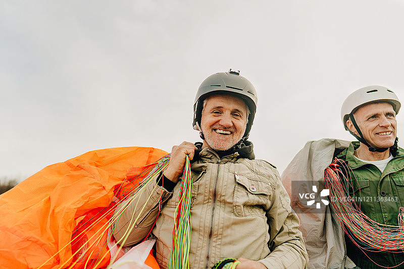 飞行结束后，年长的男人背着降落伞图片素材