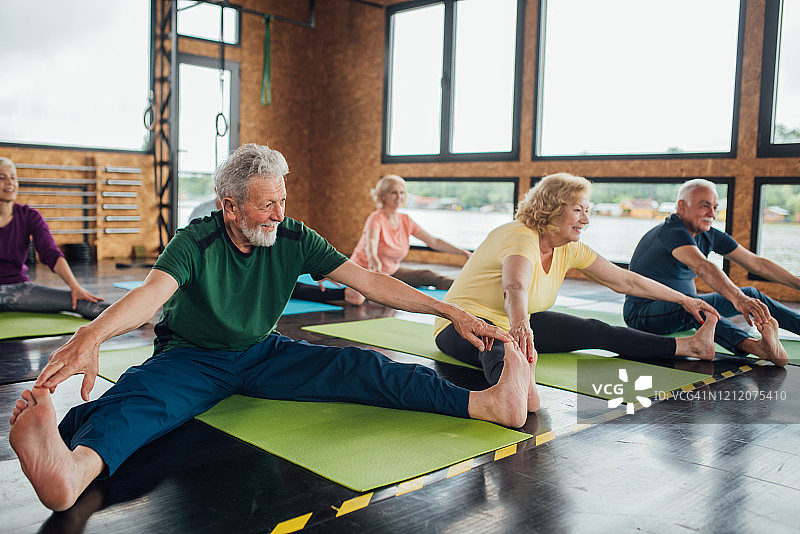 一群老年人在瑜伽课上伸展身体图片素材