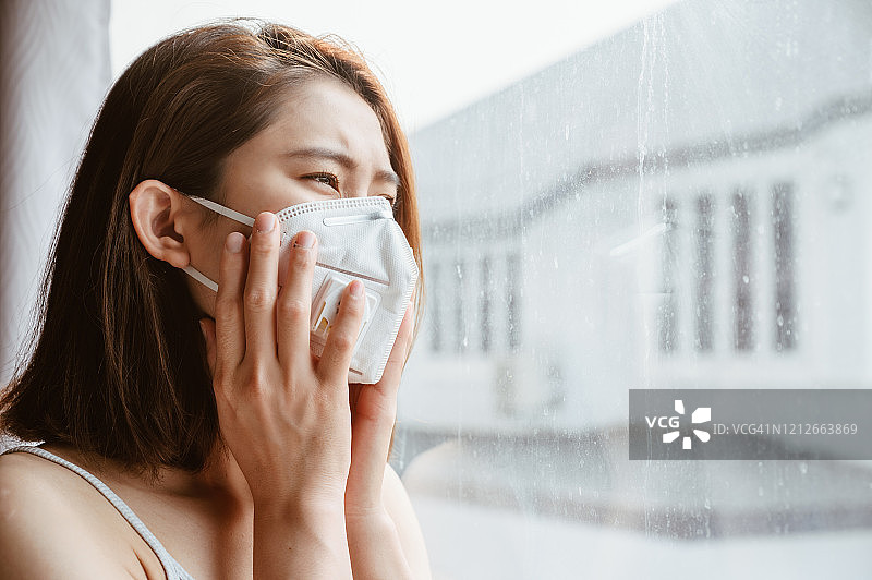 亚洲妇女在外出前戴着防尘口罩以防止PM2.5污染的肖像。图片素材