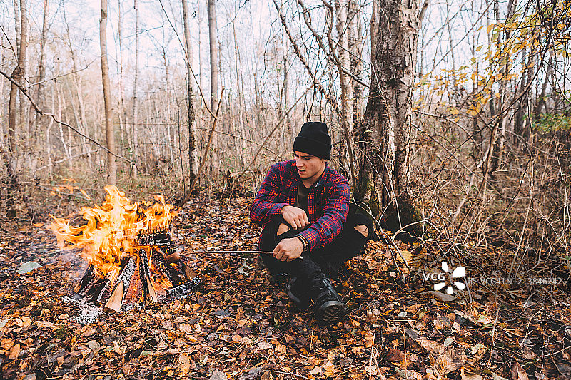 一个人坐在篝火旁，享受着气氛。图片素材