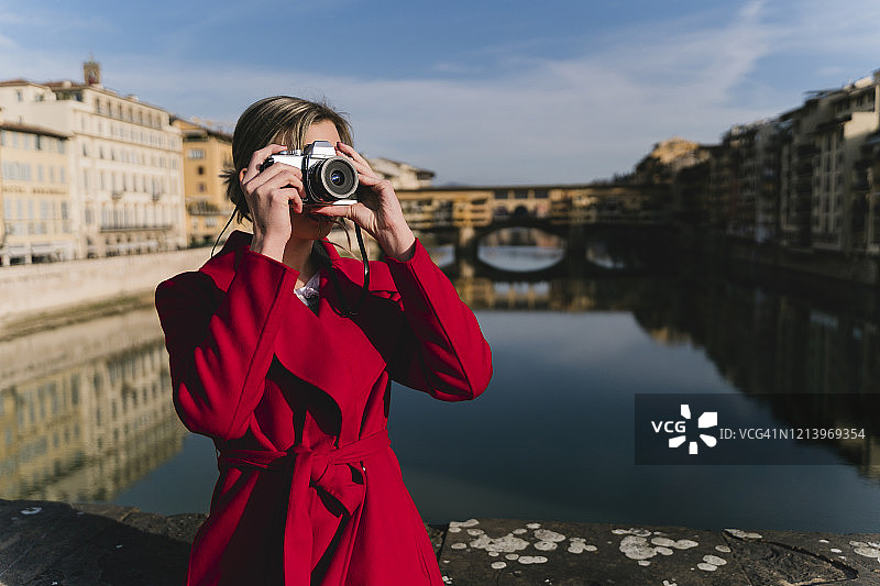 一名年轻女子在意大利佛罗伦萨亚诺河上的一座桥上拍照图片素材