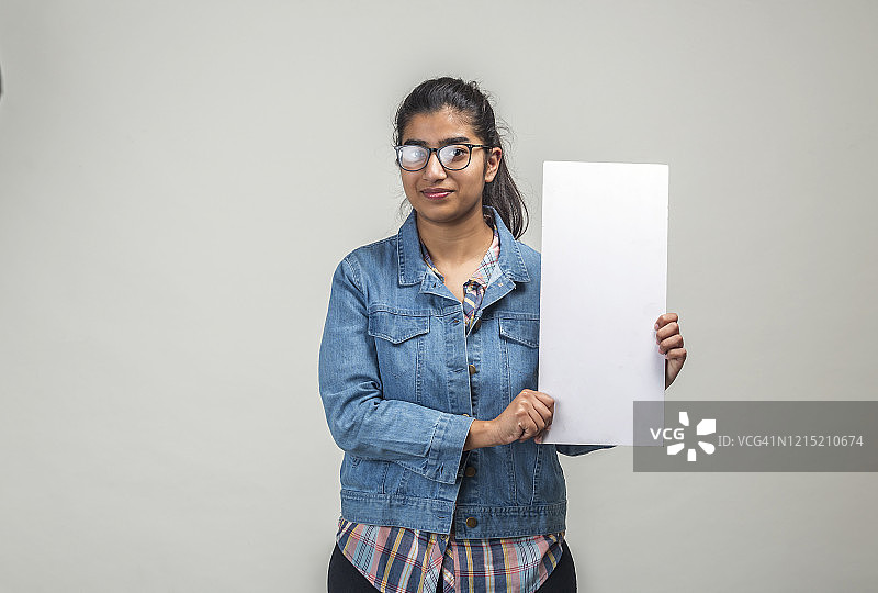 一个戴着眼镜，拿着空白牌子的印度少女图片素材