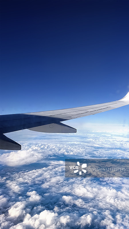鸟瞰图从飞机窗口，飞机机翼和云图片素材