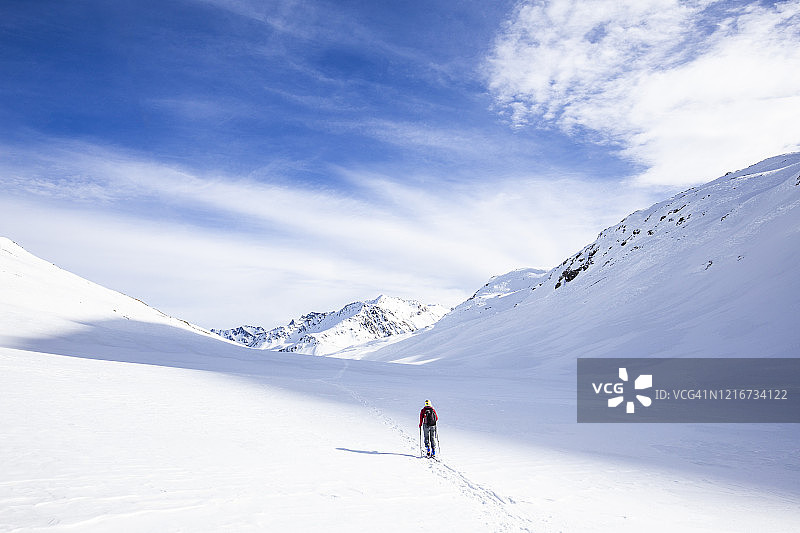 单人滑雪游客与滑雪板在新雪中行走。图片素材