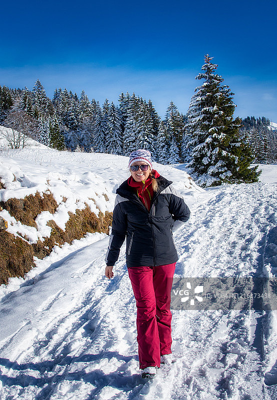 在雪中行走的微笑女人，瑞士施维茨的贝贝尔格鸡蛋图片素材