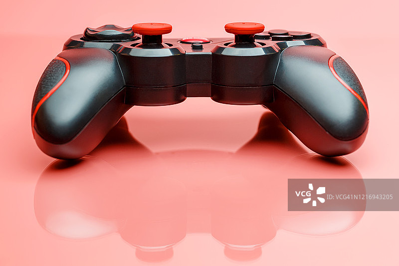 游戏手柄上的背景为粉红色。控制和控制游戏的设备图片素材
