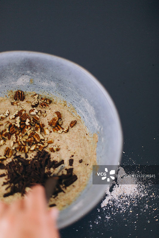 制作素食香蕉面包:用手搅拌面团，加入巧克力片和坚果片图片素材