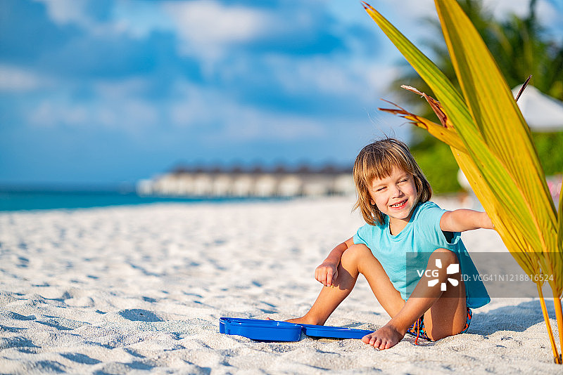 小男孩在沙滩上玩沙子图片素材