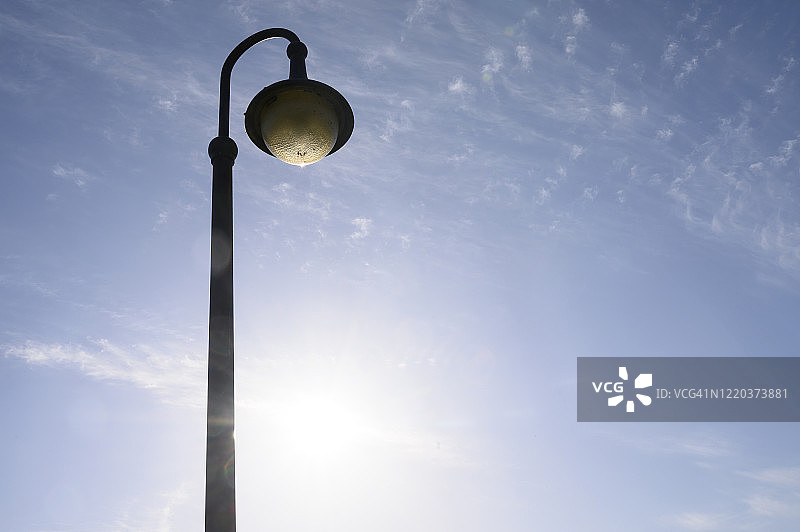 路灯背光在一个晴朗的日子，蓝天和只有几朵小云。德国图片素材