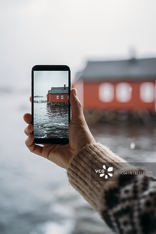 挪威罗浮敦海岸，游客用手机拍下一间小屋的特写图片素材