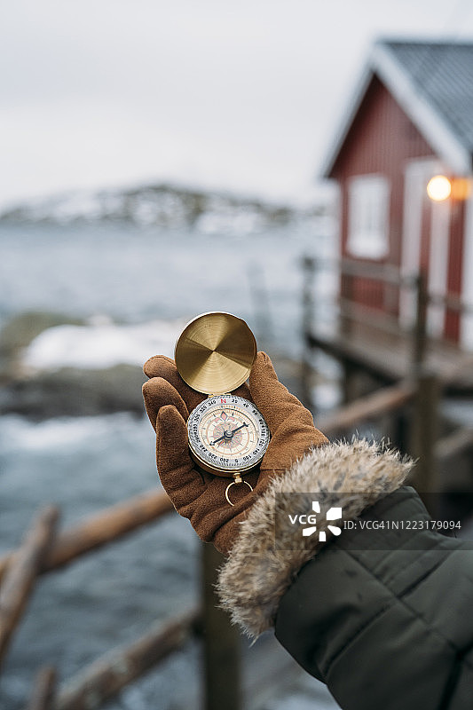 挪威罗浮敦海岸手持指南针的特写图片素材
