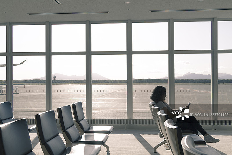 年轻游客独自在机场候机室等候图片素材