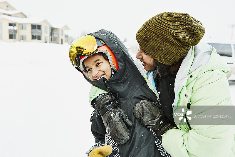滑雪前，妈妈笑着拥抱儿子图片素材