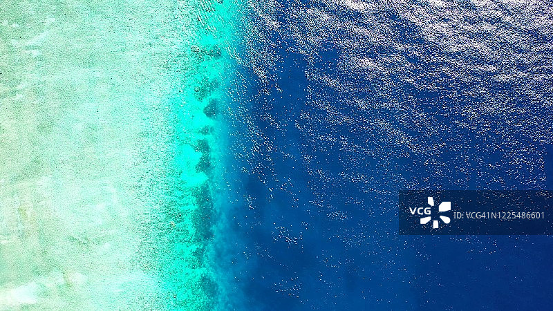 美丽的浅水湖海岸线，清澈的海水下的珊瑚礁和岩石，冲刷着多米尼加共和国热带岛屿的岩石海岸线图片素材