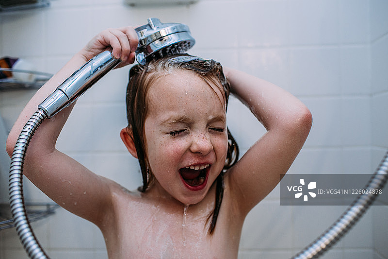 小女孩在淋浴时用洗发水冲洗头发的特写图片素材