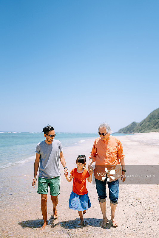 日本，一家三代在海滩上散步图片素材