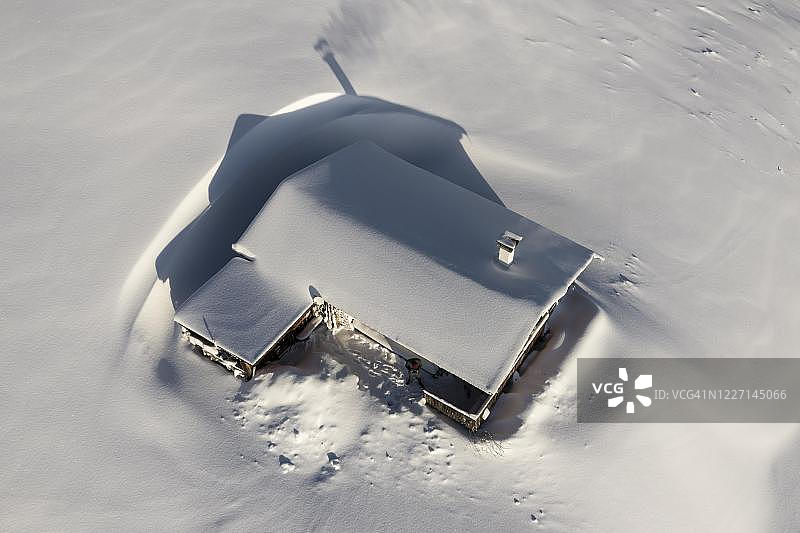 奥地利蒂罗尔，Brixen im Thale，冬天白雪覆盖的山上小屋，屋顶被雪覆盖图片素材