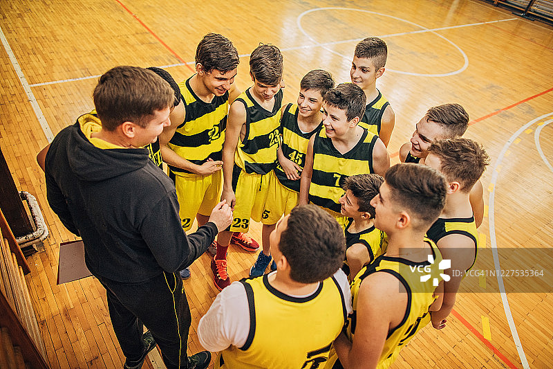 少年男子篮球队在休息时间与教练谈话图片素材
