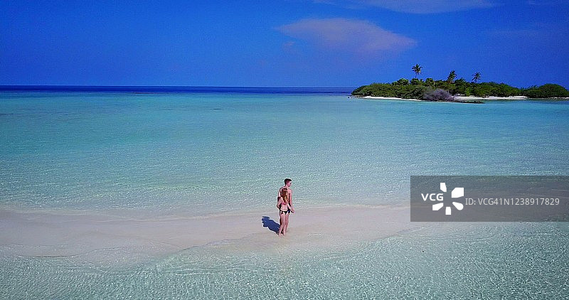 新婚夫妇在度蜜月，站在海边，望着马尔代夫的地平线图片素材