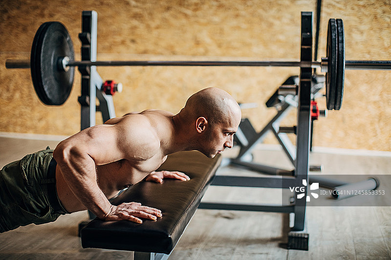 肌肉发达的男人在健身房做仰卧起坐图片素材