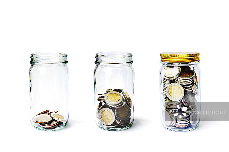硬币罐中踏成长，概念省钱或投资理财。三个玻璃瓶盖上了盖子图片素材