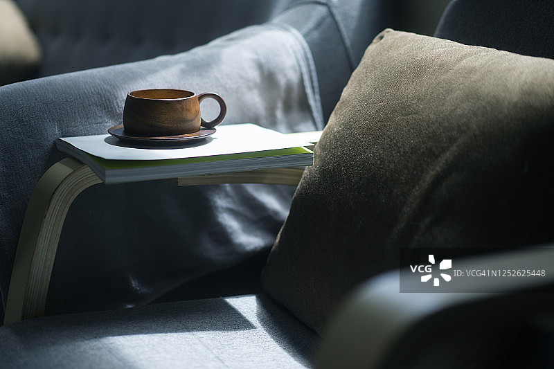木制咖啡杯放在舒适的沙发床上图片素材