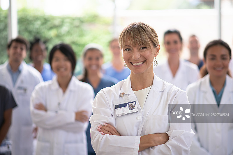 女医生微笑着与医疗队在她身后的距离图片素材