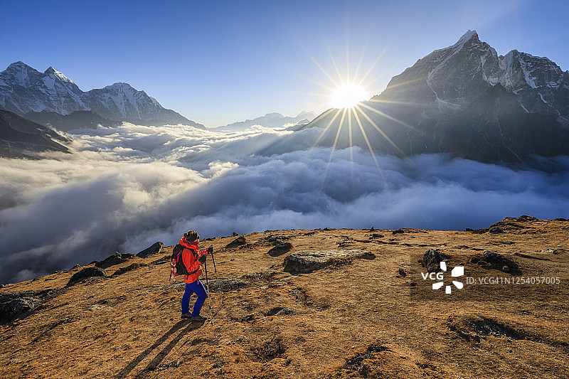 在珠穆朗玛峰地区，日落前在喜马拉雅山徒步旅行的妇女图片素材
