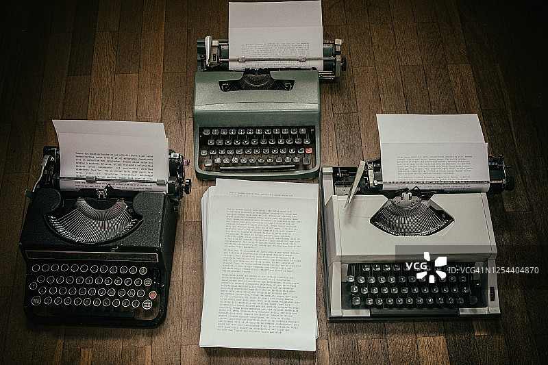 三台老式打字机在一个充满阴郁气氛的顶点静物画中图片素材