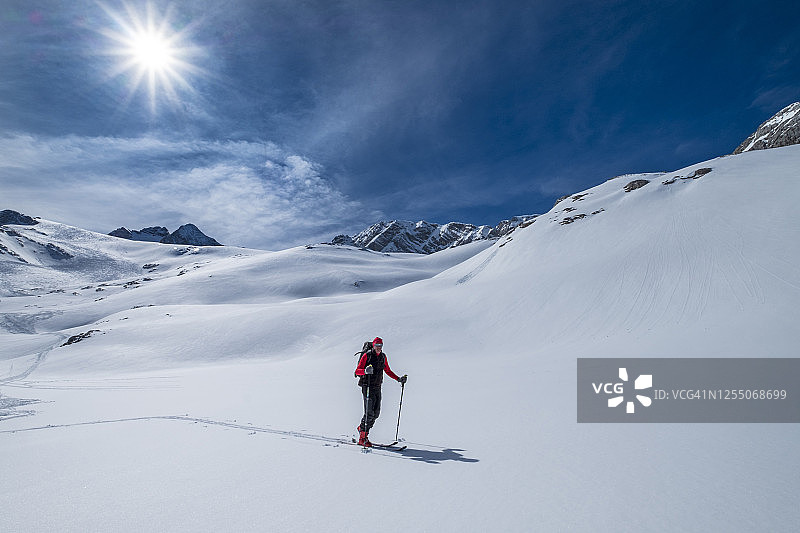 在奥地利达赫斯坦的阳光明媚的日子里，一名老人在雪地上滑雪图片素材
