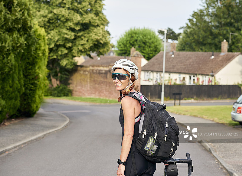 成年女性骑自行车在路上行走图片素材