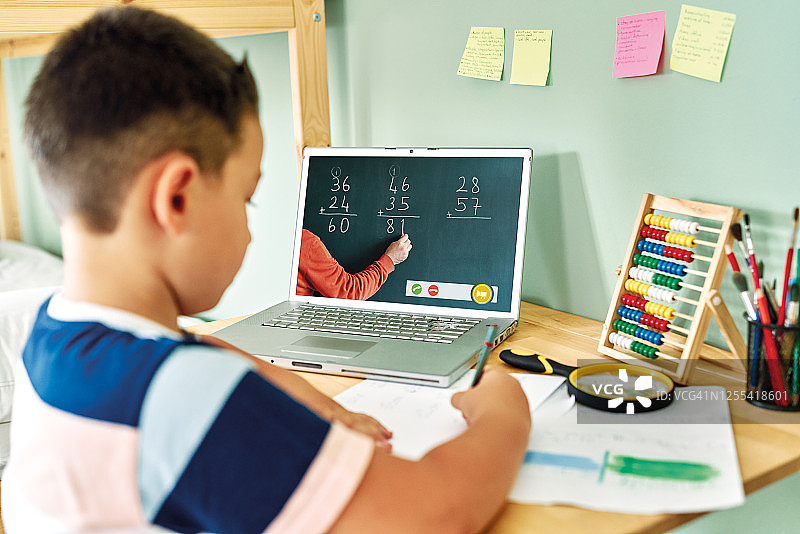 6-7岁可爱的孩子从电脑学习数学。在家教育图片素材