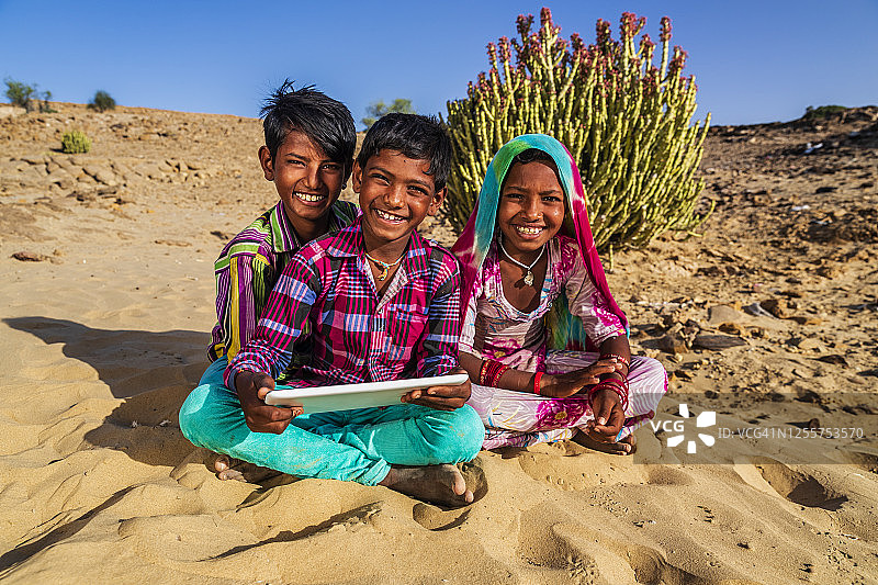 一群快乐的吉普赛印度儿童使用数字平板电脑，印度图片素材