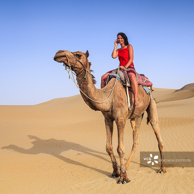 印度拉贾斯坦邦，年轻女性游客骑在骆驼上图片素材