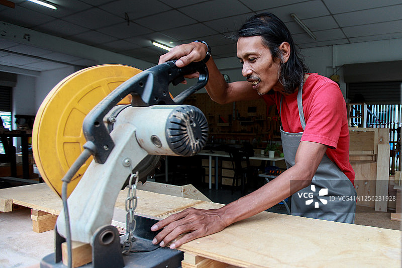 小型企业-木匠使用电动工具在他的车间图片素材