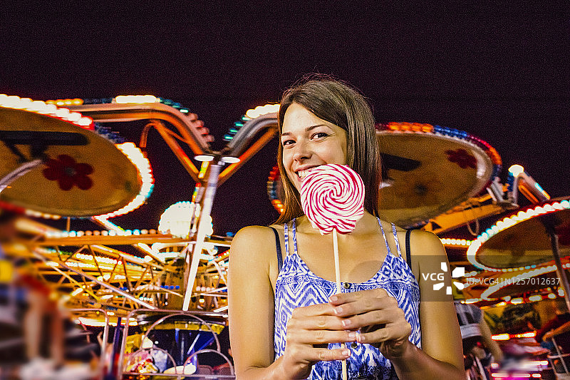 在游乐园吃棒棒糖的女人图片素材