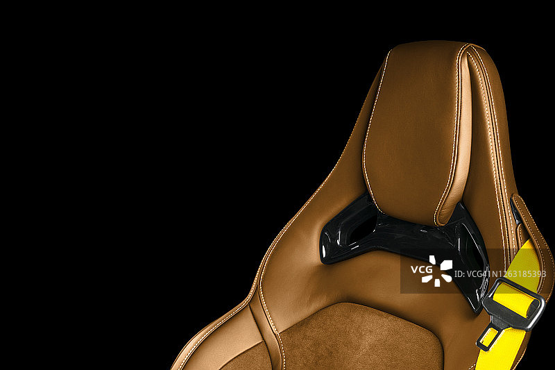 豪华现代汽车的棕色皮革内饰。穿孔棕色皮革舒适座椅与缝线隔离在黑色背景。现代汽车内部细节。汽车详细。汽车内部图片素材