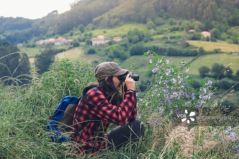 年轻女子用双筒望远镜观察绿色的大自然图片素材