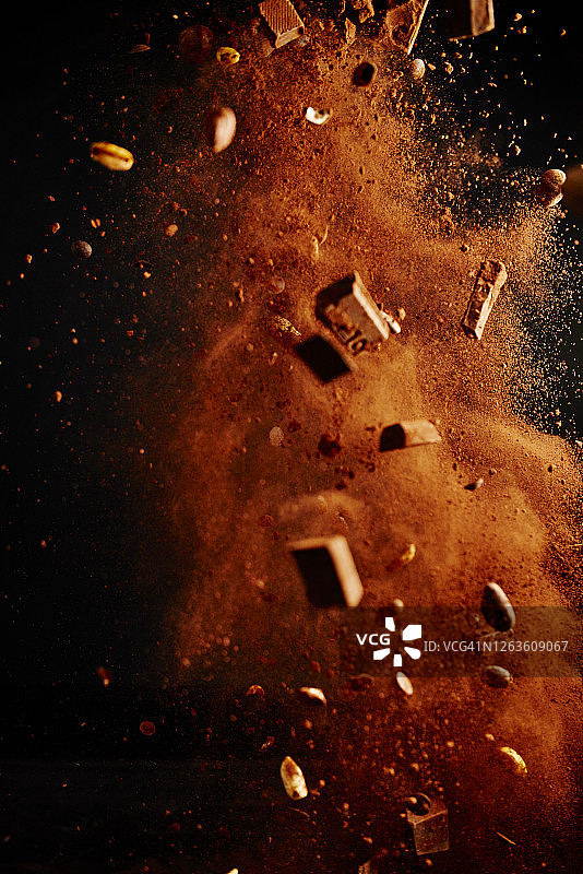 巧克力食品爆炸与可可粉，巧克力片和坚果图片素材