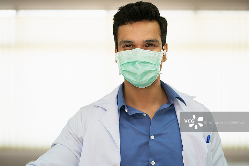 快乐的医生亚洲人在面具下微笑站在病房病房图片素材