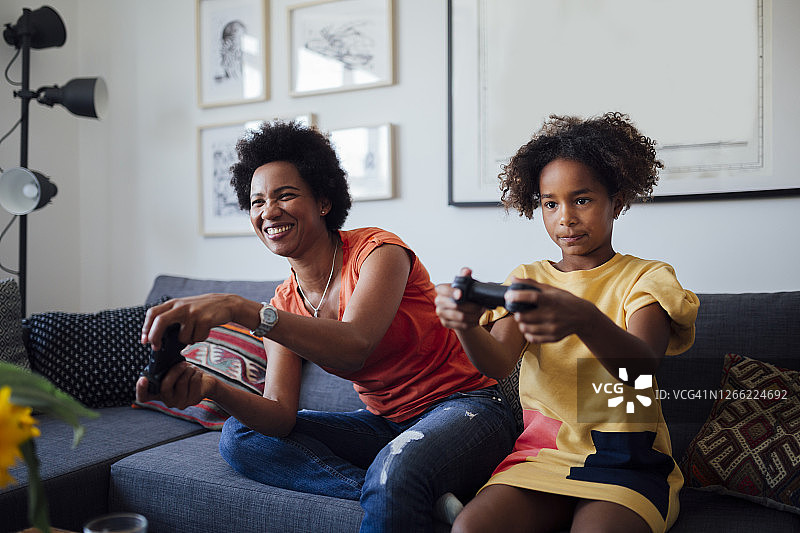 快乐的非裔美国母女在家里玩电子游戏图片素材
