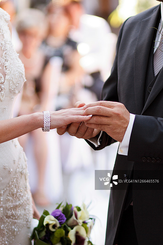 新郎将戒指戴在新娘的手上图片素材